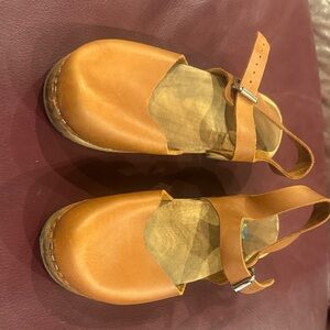 Brown leather clogs.